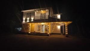 a house lit up at night with lights on it at Sintra Villa in Meppādi