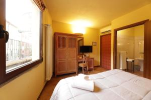 a bedroom with a bed and a window and a desk at Hotel Locanda dell'Oca Bianca in Como