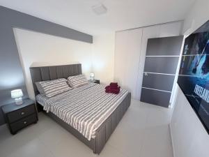 a bedroom with a large bed with a red bag on it at Playa el Ángel Apartment in Pampatar