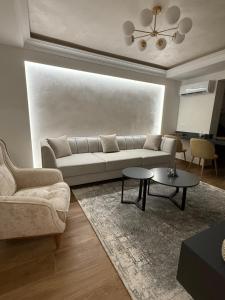 a living room with a couch and a table at Oasis Apartament in Fier +6 photos