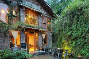 uma casa de tijolos com uma mesa e uma varanda em Tong Sang Art Hotel em Liping