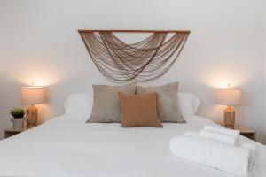 a bedroom with a white bed with two lamps at Urban Float in Colorado Springs