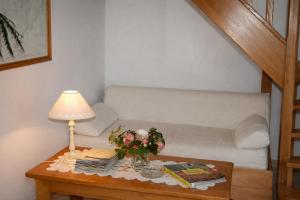 a table with a lamp and books and a couch at De Cian in Saint-Valéry-sur-Somme