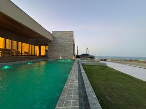 a swimming pool in front of a building at Casa riviera in Aquiraz