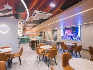 a dining room with tables and chairs and a tv at ibis Curitiba Shopping in Curitiba