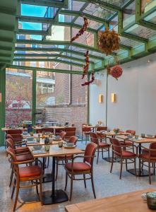 a dining room with tables and chairs and windows at Maison Haas Hustinx & Spa in Maastricht