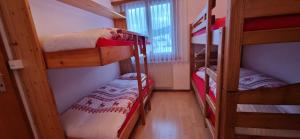 a small room with three bunk beds and a window at Pic-Chaussy B14 in Les Mosses