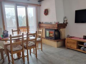 a living room with a table and a fireplace at Pic-Chaussy B14 in Les Mosses