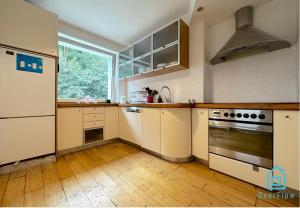 a kitchen with white cabinets and a large window at Deer Room - 5 Minutes to Sopot Molo & Seaside in Sopot