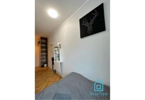 a bedroom with a bed and a picture on the wall at Deer Room - 5 Minutes to Sopot Molo & Seaside in Sopot