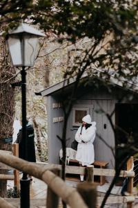 a person dressed in white standing in front of a shed at Watersmeet Terrace in Lynmouth