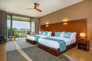 a bedroom with two beds and a balcony at Trio Lodge- Habarana in Habarana