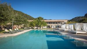 a swimming pool with lounge chairs and a building at Finca Binibona Parc Natural in Binibona