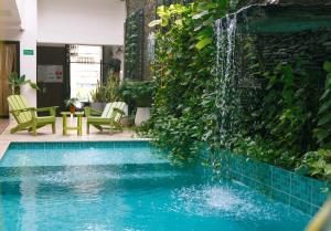 a swimming pool with a waterfall in a building at La Brisa Loca Prime in Santa Marta