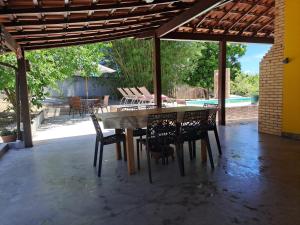 a table and chairs on a patio with a pool at Pouso Zen in Araruama