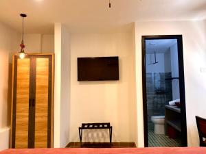 a room with a bathroom with a toilet and a television at La Brisa Loca Prime in Santa Marta
