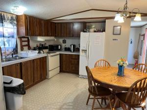 a kitchen with a wooden table and a kitchen with a refrigerator at Smokey Mountain Overlook in Bryson City