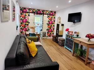 a living room with a black couch and a tv at Loft La buena vida in Peñaranda de Duero