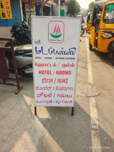 a sign on the side of a street with writing on it at Sri Madapallii in Tiruchirappalli