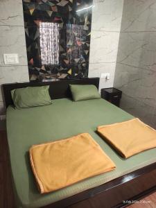 a green bed with two towels on top of it at Sri Madapallii in Tiruchirappalli
