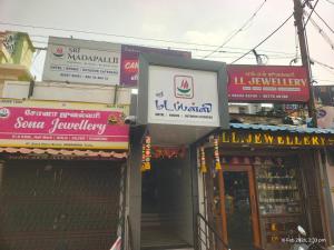 a group of shops on a city street with signs at Sri Madapallii in Tiruchirappalli +1 photo