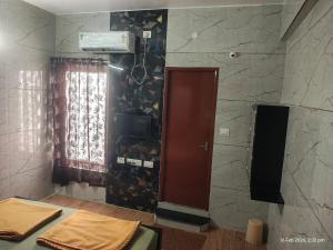 a room with a wall with a tv and a window at Sri Madapallii in Tiruchirappalli