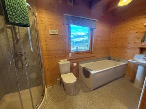 a bathroom with a tub and a toilet and a sink at Alpine Lodge in Pentney +22 photos