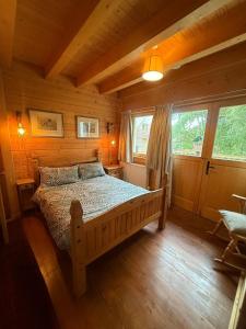 a bedroom with a bed in a log cabin at Alpine Lodge in Pentney