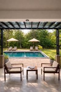 a swimming pool with chairs and umbrellas at Maho Boutique Hotel in Anuradhapura +46 photos