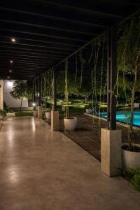 a building with a row of potted trees at night at Maho Boutique Hotel in Anuradhapura