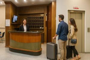 a man and woman standing at a bar with luggage at Hotel SoleMare in Diano Marina