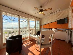 a living room with a ceiling fan and large windows at Beach House Victoria - Beachside - Playa Rincón in Rincón de la Victoria