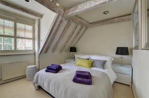a bedroom with a large bed with purple pillows on it at 2 Bed in Tunbridge Wells oc-tw660 in Royal Tunbridge Wells