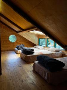 a room with three beds in a attic at ChacraKremen in El Bolsón