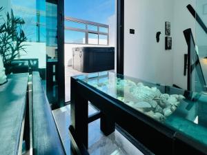 a glass aquarium with rocks in it on a balcony at Atlantic Green 3 Apartment, Terrace, Solarium and Spa in El Cotillo
