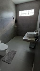 a bathroom with a sink and a toilet and a window at Villa Kitima homestay in Ban Chat +11 photos