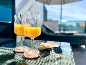 two glasses of orange juice and bread on a table at Atlantic Green 3 Apartment, Terrace, Solarium and Spa in El Cotillo
