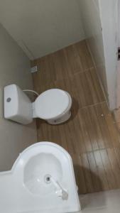 a white toilet in a bathroom with a wooden floor at Casa por do sol Flecheiras in Flecheiras +81 photos