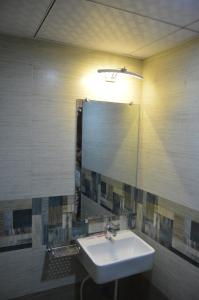a bathroom with a sink and a large mirror at Hotel A. K. International - Fort in Mumbai