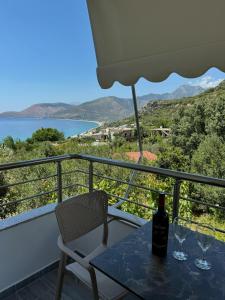 a bottle of wine sitting on a table on a balcony at Tophill Apartments in Borsh