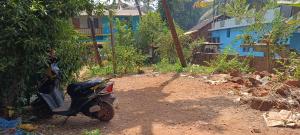 a motorcycle parked on a dirt road next to a house at Sheshatara Homestay in Honāvar +10 photos