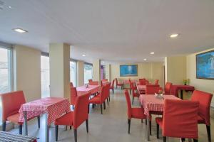 a dining room with red tables and chairs at Super Townhouse Hills Palace in Ooty