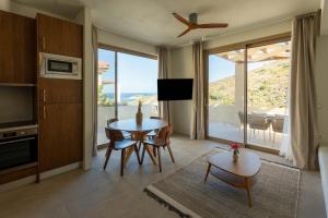 a living room with a table and a kitchen with a view at Oleander Evia in Agioi Apostoli