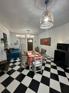 a living room with a table and a checkered floor at Hospedaje San Vicente in San Vicente