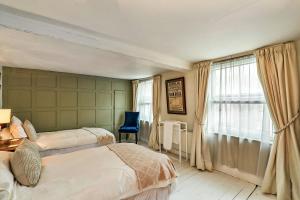 a bedroom with two beds and a desk and a window at Finest Retreats - Aarons in Painswick