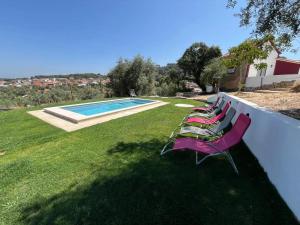 a row of chairs sitting next to a swimming pool at AlcaidariaVista in Ourém