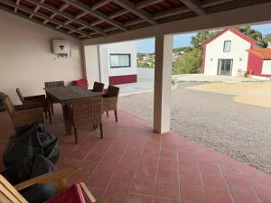 a patio with a table and chairs and a house at AlcaidariaVista in Ourém