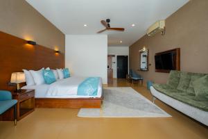 a hotel room with a bed and a couch at Trio Lodge- Habarana in Habarana