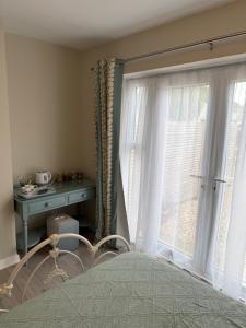 a bedroom with a bed and a window with white curtains at Starfish Snug in Brixham