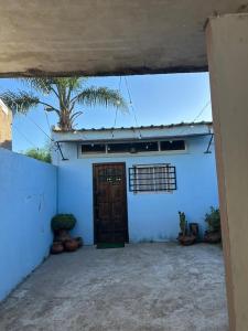 a white building with a door and a palm tree at Hospedaje San Vicente in San Vicente